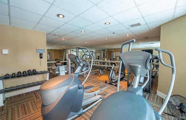 gym featuring a drop ceiling and carpet flooring