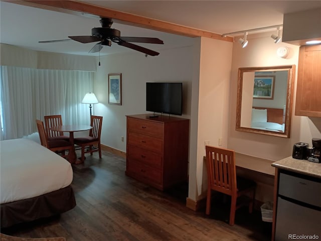 bedroom with track lighting and dark hardwood / wood-style flooring