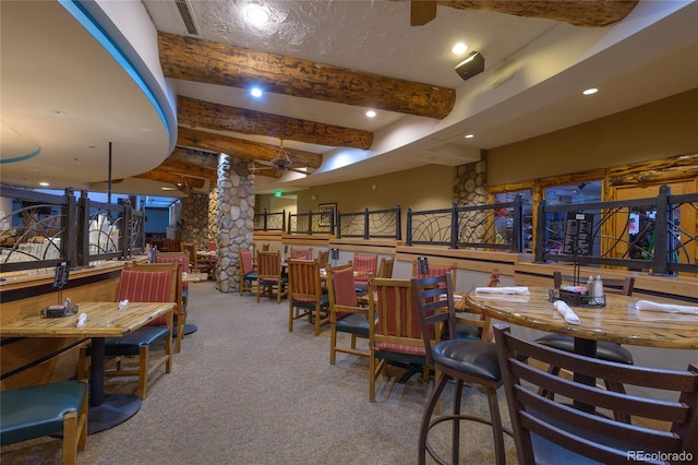 6 Emmons Rd Unit 515, Mount Crested Butte, CO 81225 - carpeted dining space with beamed ceiling, a community bar, ornate columns, and recessed lighting