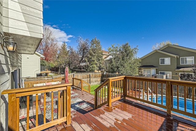 wooden terrace featuring a fenced in pool