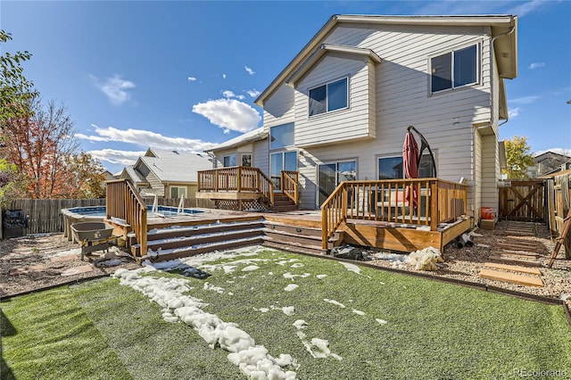 rear view of house featuring a wooden deck and a yard