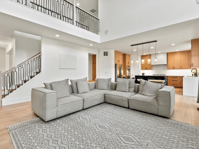 2463 Tavern Way, Castle Rock, CO 80104 - living area featuring light wood finished floors, a towering ceiling, recessed lighting, and stairway
