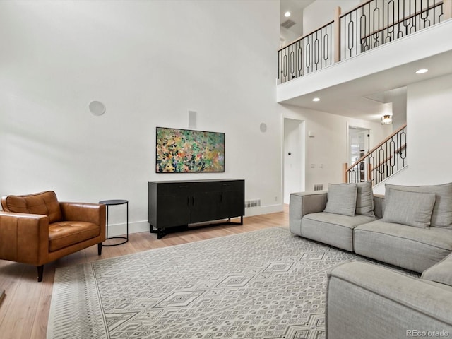 2463 Tavern Way, Castle Rock, CO 80104 - living area featuring a towering ceiling, wood finished floors, stairs, baseboards, and recessed lighting