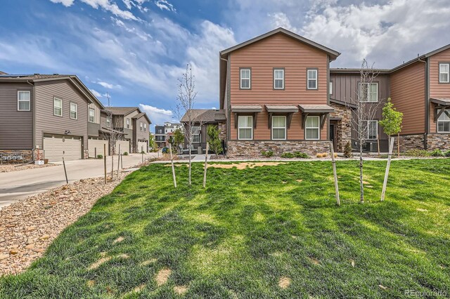 8433 Mount Kataka Loop, Littleton, CO 80125 - view of front of property with stone siding, an attached garage, a residential view, concrete driveway, and a front yard