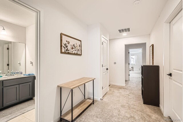 8433 Mount Kataka Loop, Littleton, CO 80125 - hallway featuring light colored carpet, visible vents, baseboards, and a sink