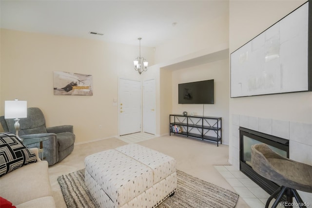 living room featuring an inviting chandelier, light colored carpet, and a tile fireplace