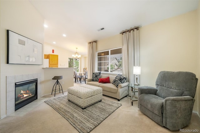 carpeted living room with a fireplace, vaulted ceiling, and a chandelier