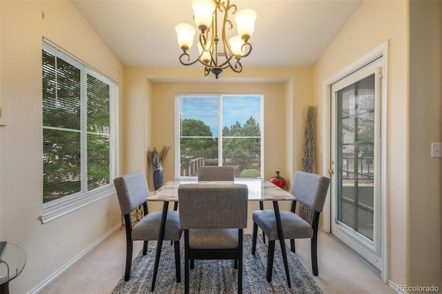 dining space featuring a healthy amount of sunlight, carpet flooring, and a chandelier