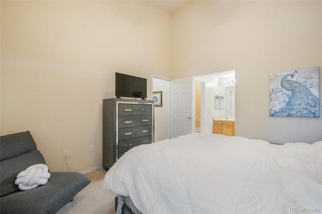 bedroom with sink, light carpet, and ensuite bath