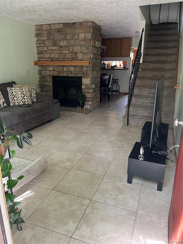 2285 S Jasper Way Unit A, Aurora, CO 80013 - living room featuring a textured ceiling, stairs, a stone fireplace, and light tile patterned floors