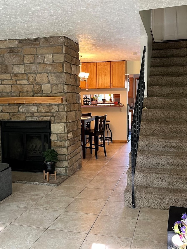 2285 S Jasper Way Unit A, Aurora, CO 80013 - living room featuring light tile patterned floors, stairway, a textured ceiling, and a fireplace