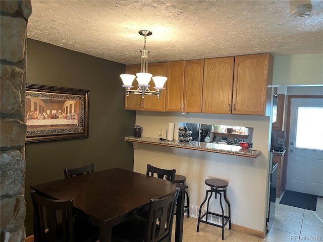 2285 S Jasper Way Unit A, Aurora, CO 80013 - dining room with a chandelier, light tile patterned floors, a textured ceiling, and baseboards