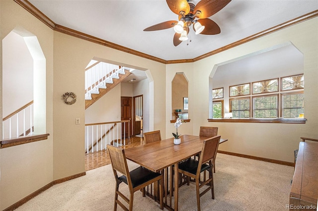 9873 Greensview Cir, Lone Tree, CO 80124 - dining area with light carpet, a ceiling fan, crown molding, arched walkways, and stairway
