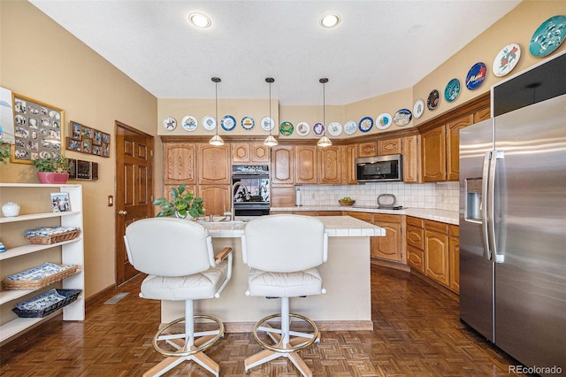 9873 Greensview Cir, Lone Tree, CO 80124 - kitchen with black appliances, an island with sink, brown cabinets, tasteful backsplash, and recessed lighting