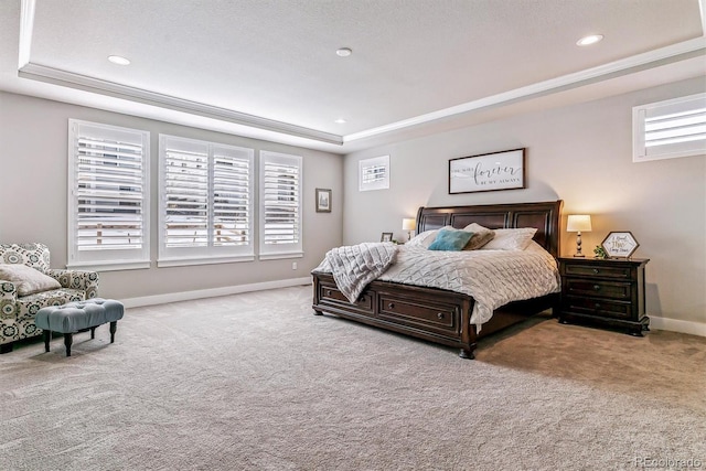 carpeted bedroom with crown molding, a raised ceiling, and multiple windows