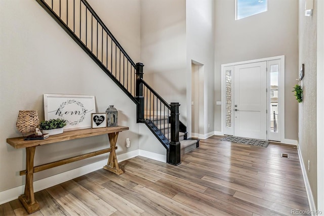 foyer featuring wood-type flooring and a high ceiling