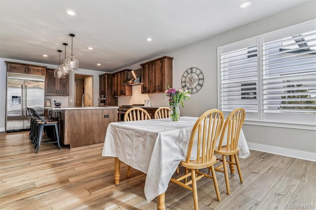 dining area with sink and light hardwood / wood-style flooring