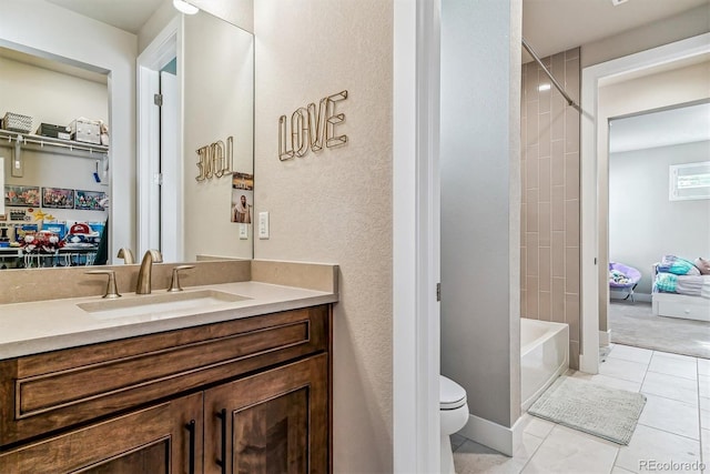 full bathroom with tiled shower / bath, tile patterned floors, toilet, and vanity