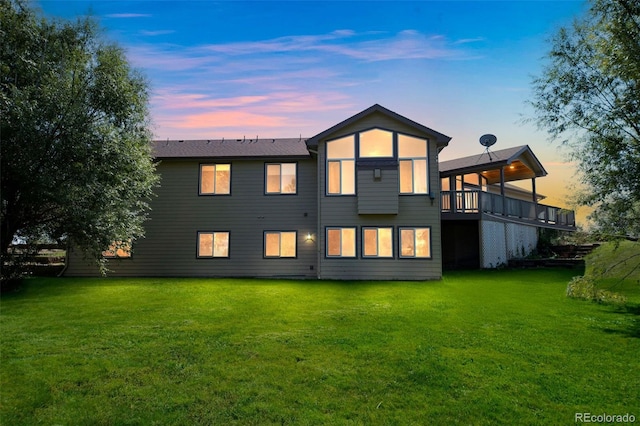 back house at dusk with a lawn