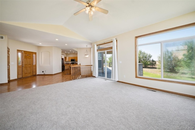 unfurnished living room with lofted ceiling, ceiling fan, and wood-type flooring