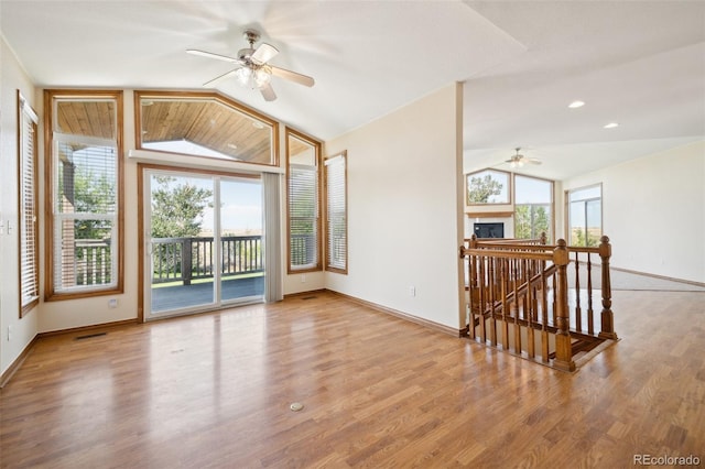 unfurnished room with light wood-type flooring, ceiling fan, and vaulted ceiling