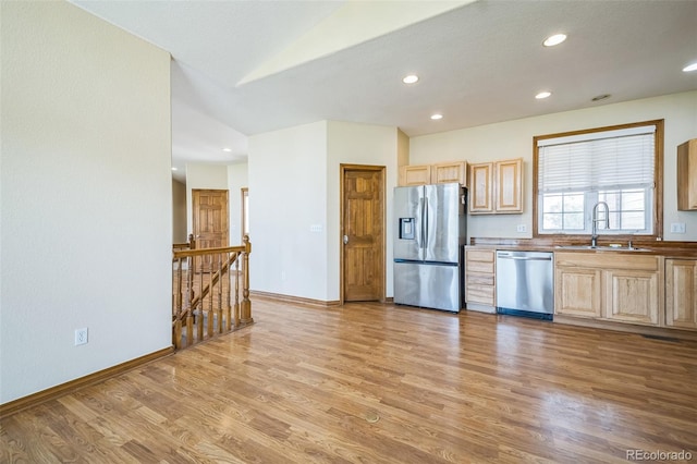 kitchen with light brown cabinetry, stainless steel appliances, light hardwood / wood-style floors, and sink