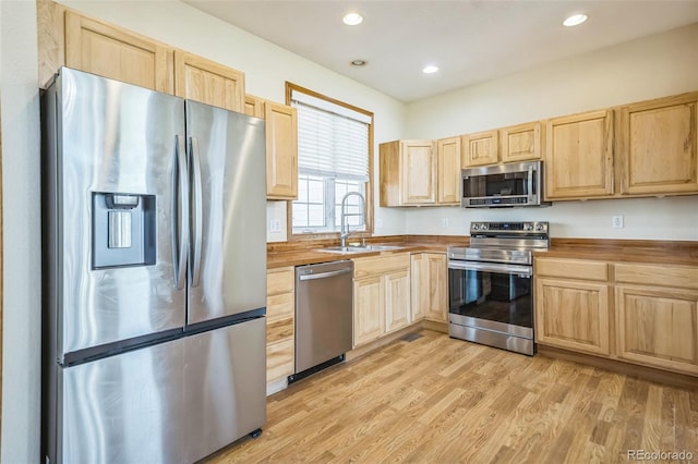 kitchen with light hardwood / wood-style flooring, appliances with stainless steel finishes, light brown cabinetry, and sink