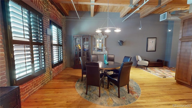 dining room featuring brick wall, wood-type flooring, beam ceiling, wood ceiling, and a chandelier