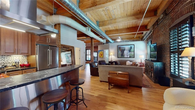 1745 Wazee St Unit 4H, Denver, CO 80202 - kitchen with freestanding refrigerator, light wood-style floors, dark countertops, a kitchen breakfast bar, and open floor plan