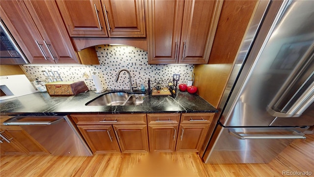 1745 Wazee St Unit 4H, Denver, CO 80202 - kitchen featuring stainless steel refrigerator, light wood-style floors, cooktop, backsplash, and brown cabinets