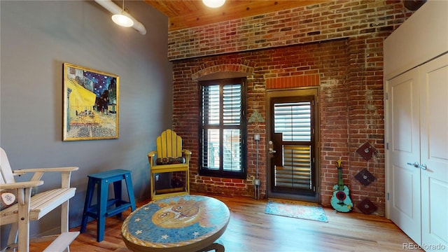 1745 Wazee St Unit 4H, Denver, CO 80202 - sitting room with brick wall, wood finished floors, and wood ceiling