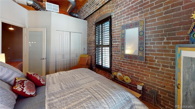 1745 Wazee St Unit 4H, Denver, CO 80202 - bedroom featuring brick wall, a towering ceiling, and a closet