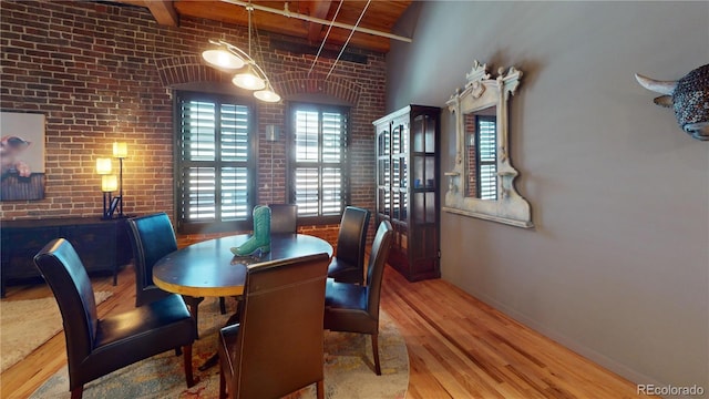 1745 Wazee St Unit 4H, Denver, CO 80202 - dining area featuring wood finished floors, beam ceiling, and brick wall