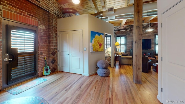 1745 Wazee St Unit 4H, Denver, CO 80202 - entrance foyer with brick wall, wood finished floors, and a wood ceiling with exposed beams