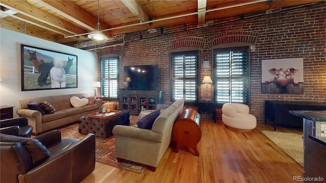 1745 Wazee St Unit 4H, Denver, CO 80202 - living room with a fireplace, wood finished floors, brick wall, and a wood ceiling with exposed beams