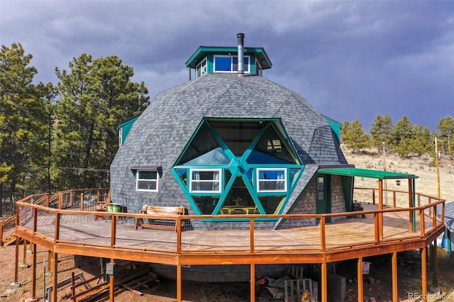 back of house with a shingled roof and a wooden deck