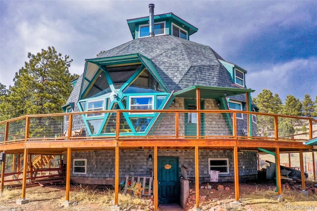 back of property featuring roof with shingles and a wooden deck