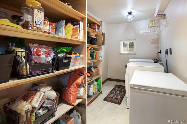 laundry area with laundry area, washer and clothes dryer, and baseboards