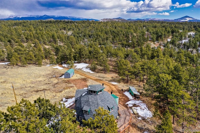 drone / aerial view featuring a mountain view and a wooded view