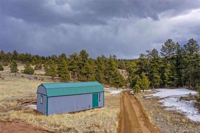 view of outbuilding with an outbuilding and a view of trees