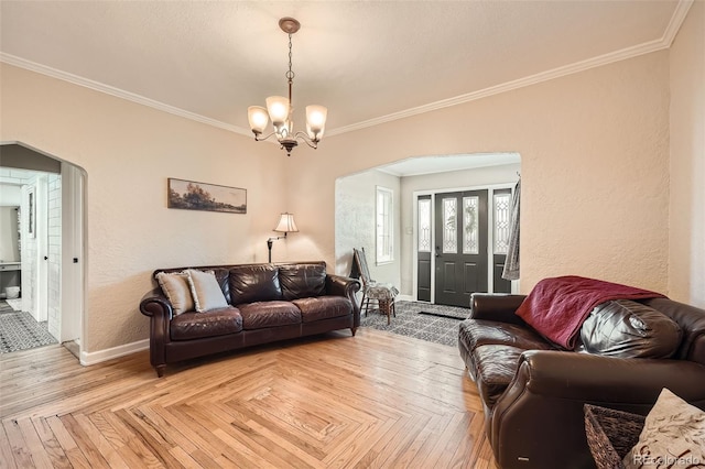 living room with baseboards, arched walkways, an inviting chandelier, and crown molding