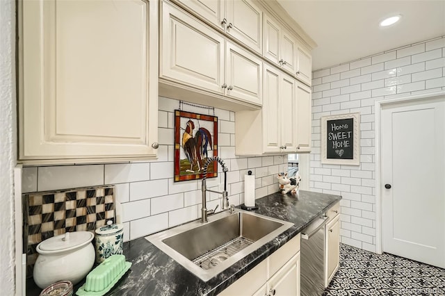 kitchen with recessed lighting, cream cabinets, stainless steel dishwasher, tile walls, and a sink