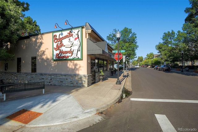 exterior space featuring street lights, traffic signs, curbs, and sidewalks