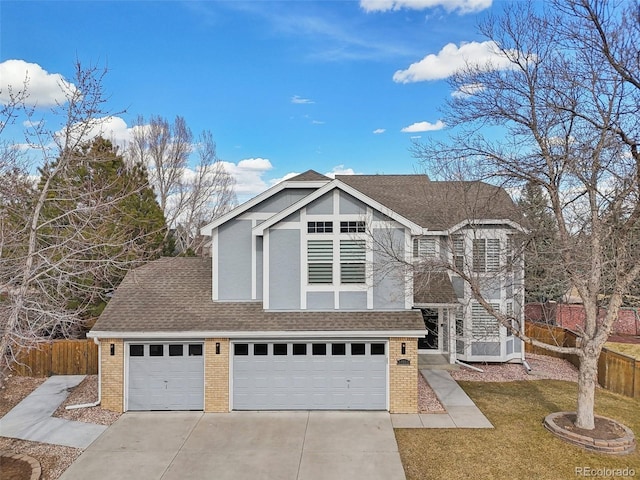 view of front facade with roof with shingles, brick siding, concrete driveway, a front yard, and fence