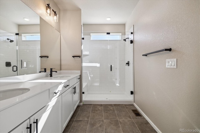 bathroom with tile patterned floors, a shower with door, and vanity