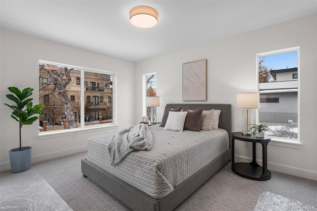 bedroom featuring light colored carpet and multiple windows