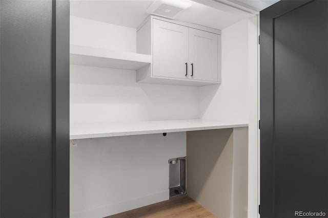 laundry area featuring cabinets and light hardwood / wood-style flooring