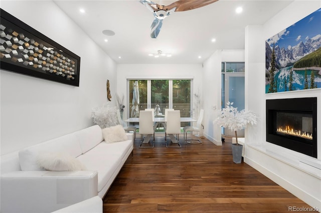 living room with dark wood-type flooring and ceiling fan