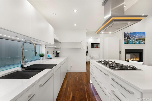 kitchen featuring white cabinets, dark wood-type flooring, sink, stainless steel gas cooktop, and island range hood