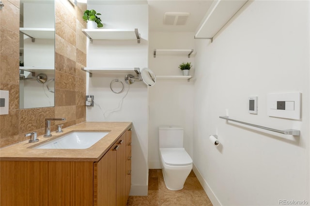 bathroom with toilet, vanity, backsplash, and tile patterned floors